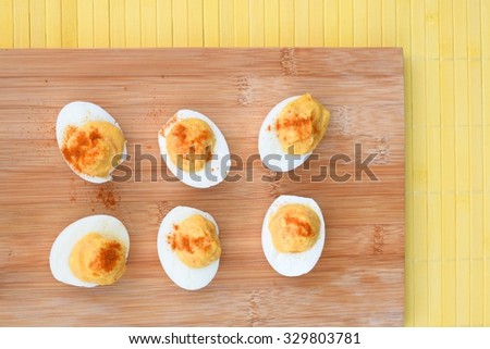 Healthy Deviled Eggs as an Appetizer on Wooden Board garnish with Paprika Powder