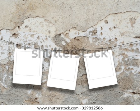 Three square instant photo frames on damaged concrete wall background