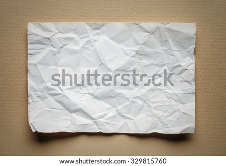 Crumpled  white paper card on beige background, place for text
