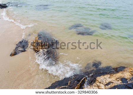 Blurred abstract background of white wave,yellow sand and black stone at Samila beach,Songkhla Southern Thailand.