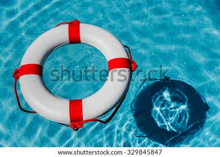 an emergency tire floating in a swimming pool. symbolic photo for rescue and crisis management in the financial crisis and banking crisis.