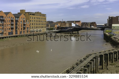 Hull, Humberside, UK. River Hull at low tide with view of Scale Lane swing bridge (open), beached obsolete ship, and flanked by buildings near the estuary, Hull, Humberside, UK. Royalty-Free Stock Photo #329885534
