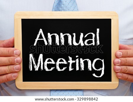 Annual Meeting - Businessman holding chalkboard with text Royalty-Free Stock Photo #329898842