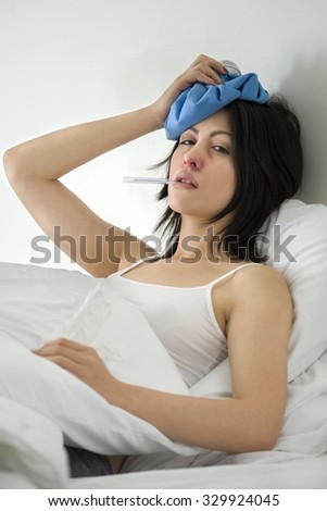 Calm Caucasian young woman with medium black hair in athletic costume using ice bag - therapy