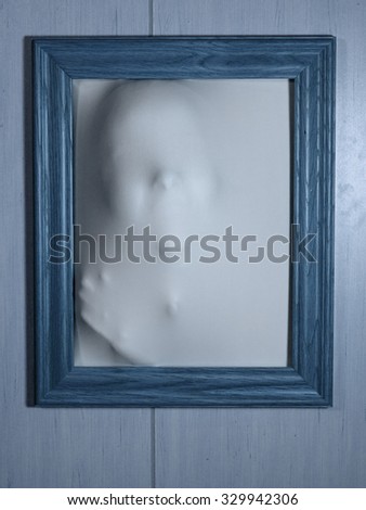 Creepy Bluetone Picture Frame with Something Coming Out of It