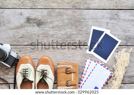 Vintage leather shoes ,leather wallet,photo frame,letter and camera on wood background.