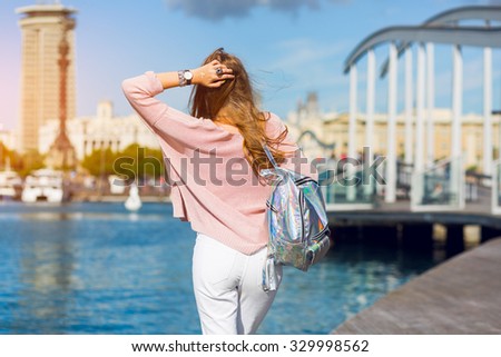 Lifestyle spring image of pretty girl posing back and arms overhead show sings , dreaming mood.  Blonde woman travels to Barcelona.Amazing view. 