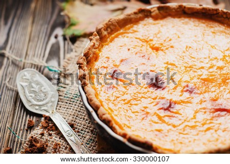 American homemade pumpkin pie , pumpkin seeds and autumn leaves on a wooden background