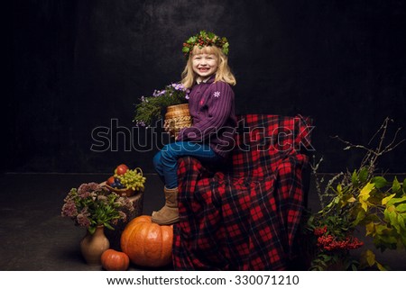 The most beautiful girl in the autumn interior in the studio on a black background.