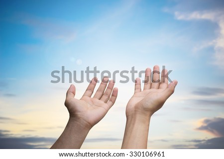 Human's hands pray on blurred beautiful sunrise nature background for receive power concept.