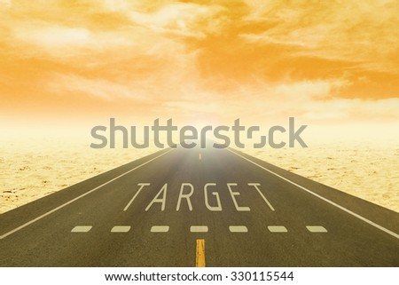 empty road through the desert with sign target on asphalt at sunset