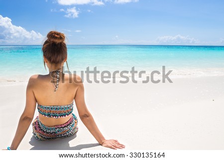 women wear bikini sitting on the beach