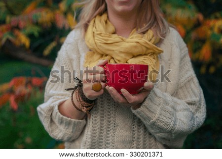 Fall concept - autumn woman drinking tea