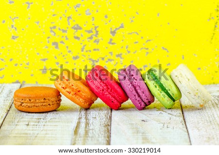 Colorful macarons on vintage pastel background. Macaron or Macaroon sweet meringue-based confection.