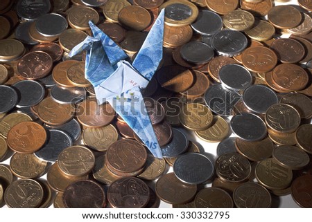 Origami crane made of brazilian money with coins