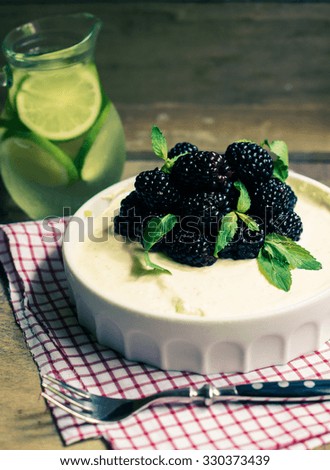 Cheesecake with blackberries and mint, selected focus. Toned picture