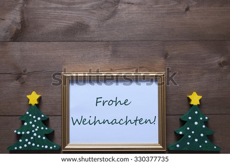 One Golden Picture Frame With Two Green Christmas Tree. German Text Frohe Weihnachten Means Merry Christmas. Christmas Card For Seasons Greetings. Decoration With Wooden, Rustic Retro Background. 