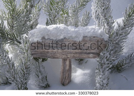 Wooden Christmas Sign With Snow And Fir Tree Branch In The Snowy Forest. Copy Space Your Text Here Or Free Space For Seasons Greetings Or Christmas Greetings Or Advertisement. Christmas Atmosphere.