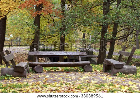 Autumn in the park. In the picture there are three wooden benches.