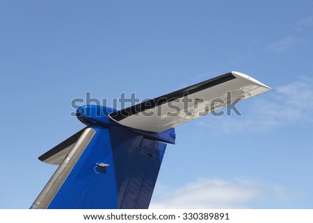 Airplane wing tale viewed from below with blue sky. Horizontal