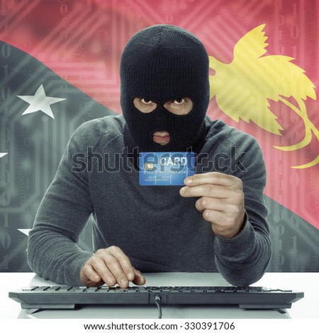 Dark-skinned hacker with credit card in hand and flag on background - Papua New Guinea