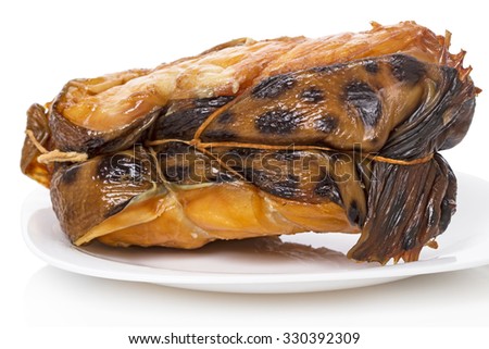A piece of smoked catfish on a white plate