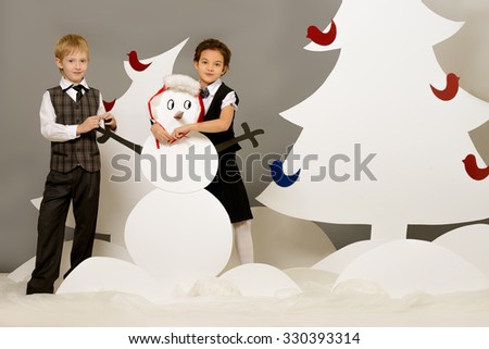 Cute girl and boy playing together in a cartoon fairy snowy forest. The magic of Christmas night. Full length portrait.