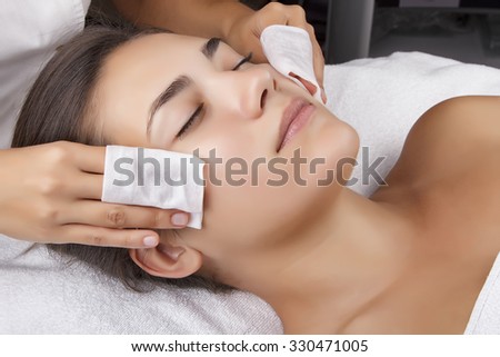 Young pretty woman receiving treatments in beauty salons. Young beautiful dark-haired woman in the office beautician lying on the couch. The procedure for cleaning the face