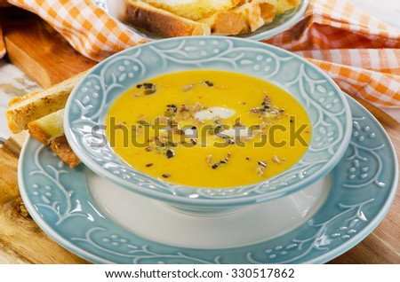 Bowl of pumpkin soup with bread crouton. Selective focus