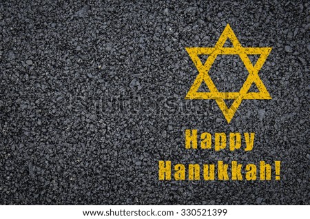 Happy Hanukkah - star of david and phrase written on asphalt background