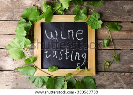 Old square chalk scripted frame with vine on wooden background