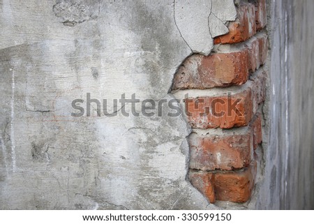 corner of a brick wall with fallen off plaster