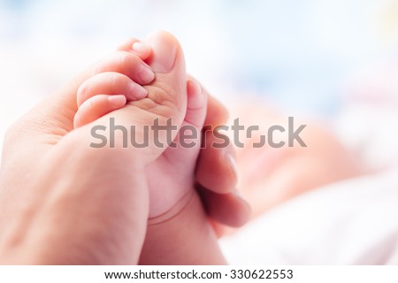 Holding Hands. hand the sleeping baby in the hand of parent close-up Royalty-Free Stock Photo #330622553