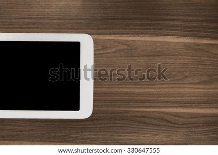 Digital tablet, white smartphone phone on old wooden desk table. Simple modern mobile workspace working business or web surfing. Dark color on screen. Lot of free spare copyspace for your content.