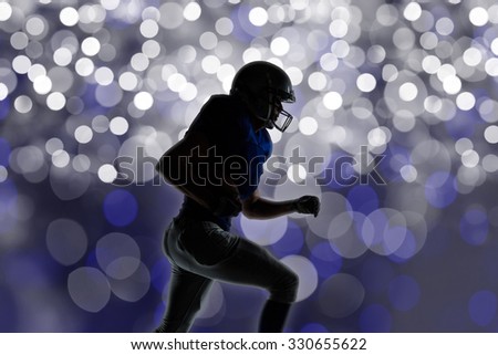 Silhouette American football player runing against glowing background