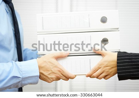 Client is passing documentation in binders to his partner Royalty-Free Stock Photo #330663044