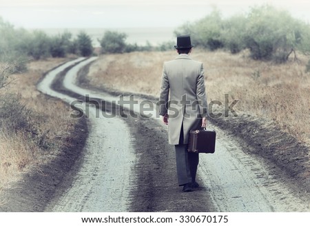 Retro style man on the country road, view from back Royalty-Free Stock Photo #330670175