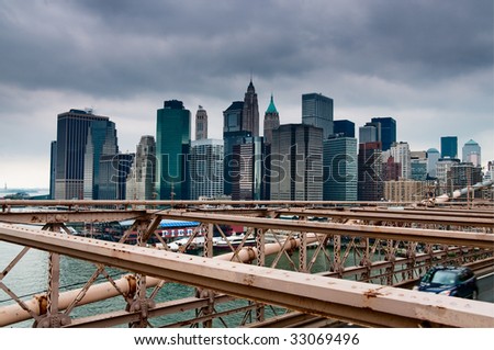 New York skyline viewed from Brooklyn Bridge with a dramatic dark sky