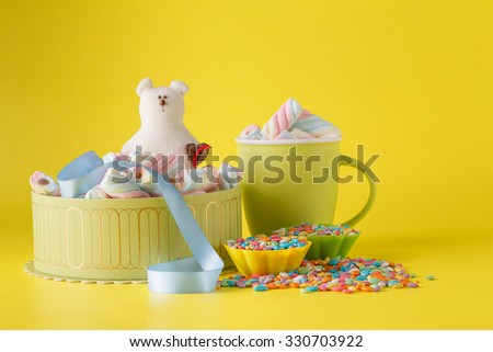 Kid sweets surprise. Marshmallow and toy on yellow background