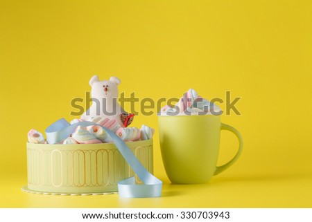 Kid sweets surprise. Marshmallow and toy on yellow background