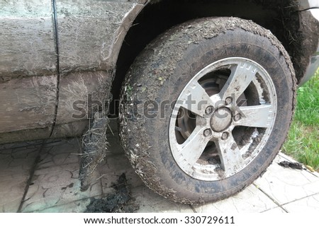 Extremely dirty SUV wheel after driving heavy off-road in the rain