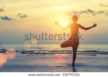 Silhouette of yoga woman on sea sunset.