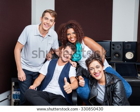 Portrait of happy multiethnic musicians in recording studio