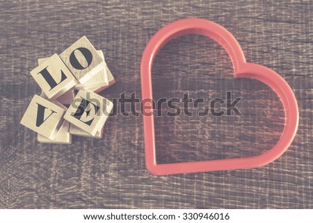 Love message formed with wooden blocks. Cross processed image for retro look