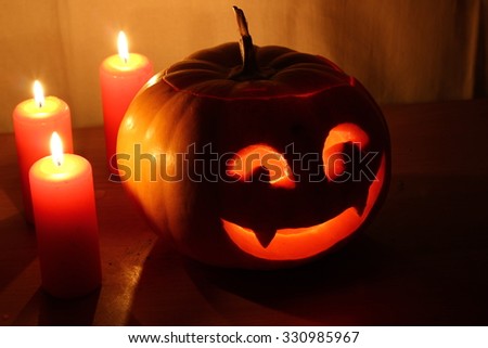 Scary Halloween pumpkin with candles on a dark background