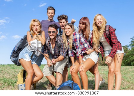 group of friends taking a self portrait with selfie stick