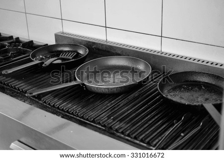 Frying pan on a cooker. Black and white photo.