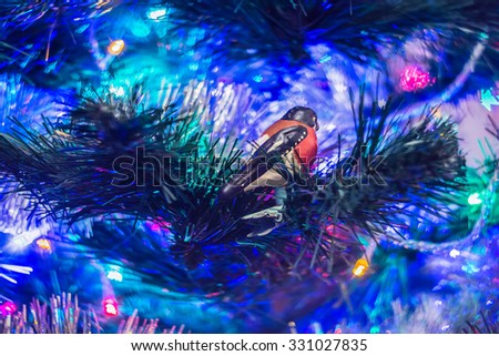 Vintage Christmas decorations on a blurred background.Vintage Christmas tree toy "bullfinch" glass on the clothespin. Manufactured in Germany at about 1900- 1940 years.
