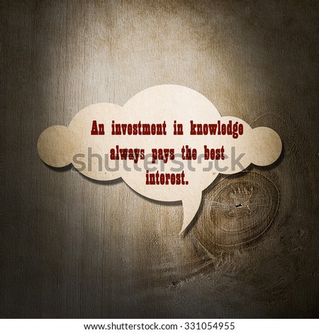 Meaningful quote on paper cloud with wooden background, An investment in knowledge always pays the best interest.