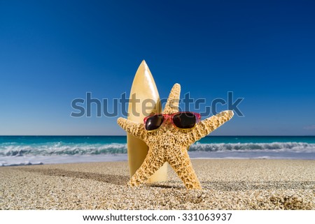 Starfish on the sandy beach wearing sunglasses and surfboard